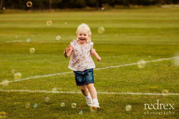 Toddler in park with bubbles